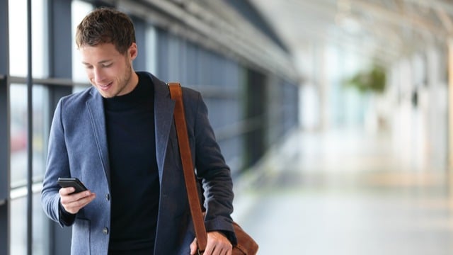 A man walking while looking at the mobilephone