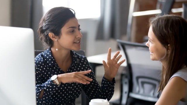 Two women talking to each other in an office