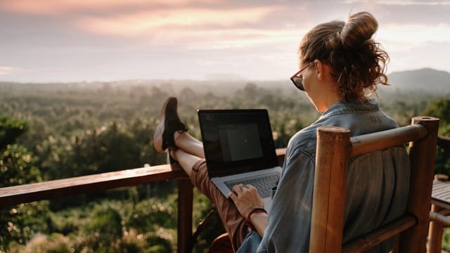 Woman working on a laptop while sitting on a chair