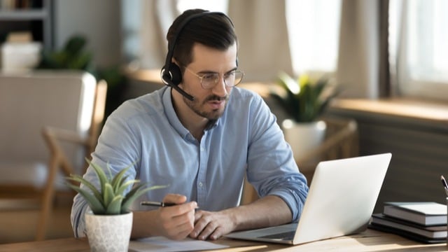 A man working on a laptop with headphones