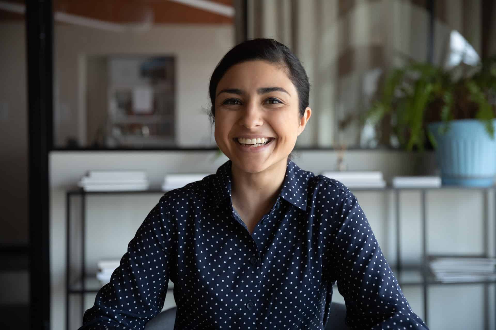 Excited young Indian ethnicity woman looking at camera.