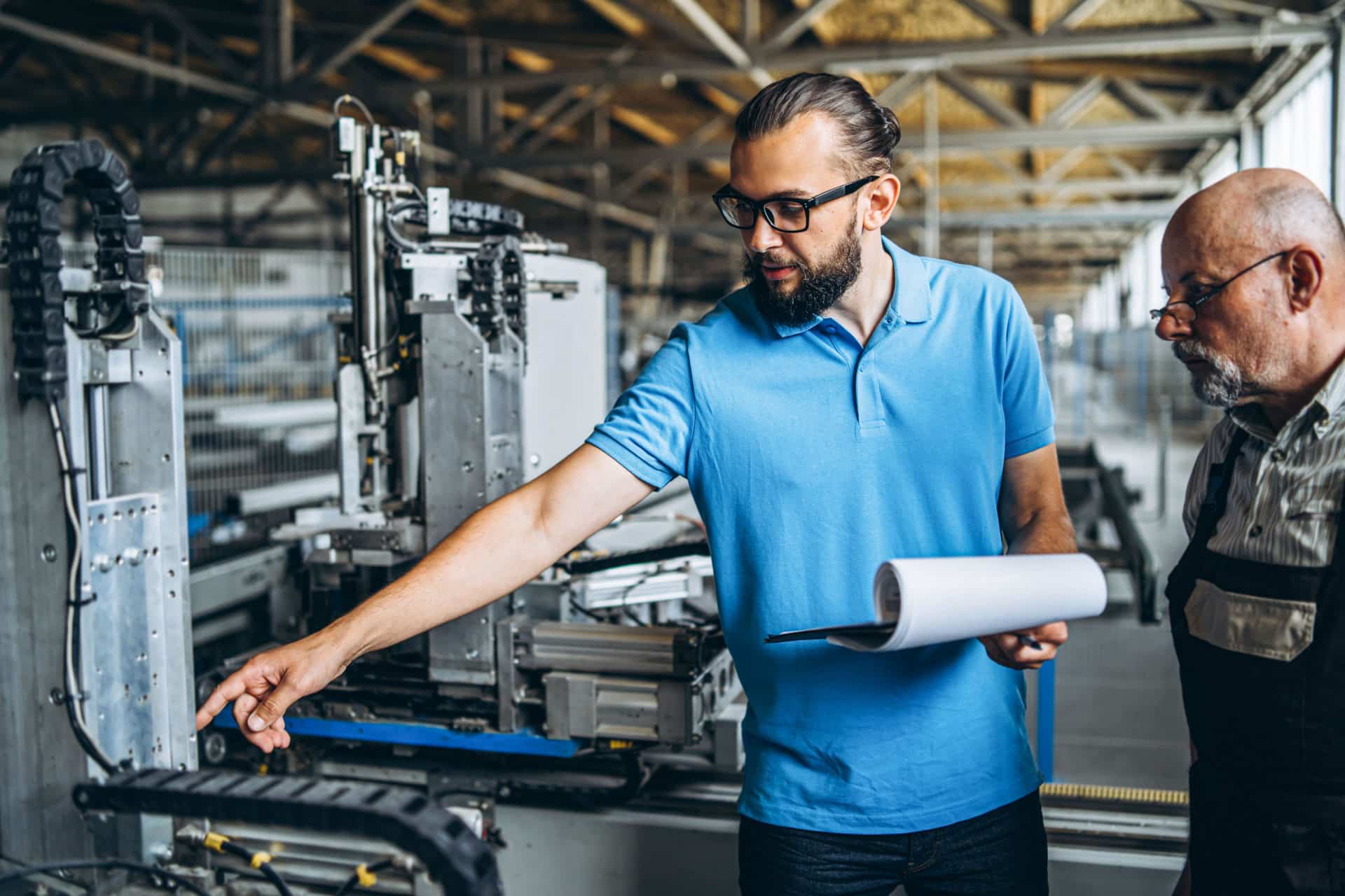Two people work at plant on special machine, focused on work