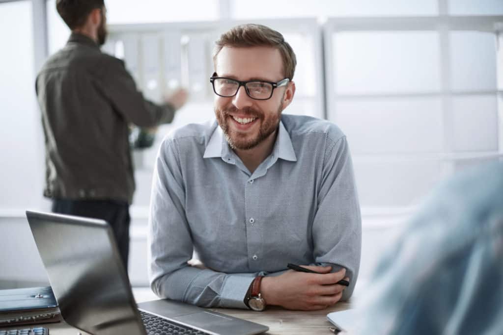 close up. smiling businessman sitting at his desk