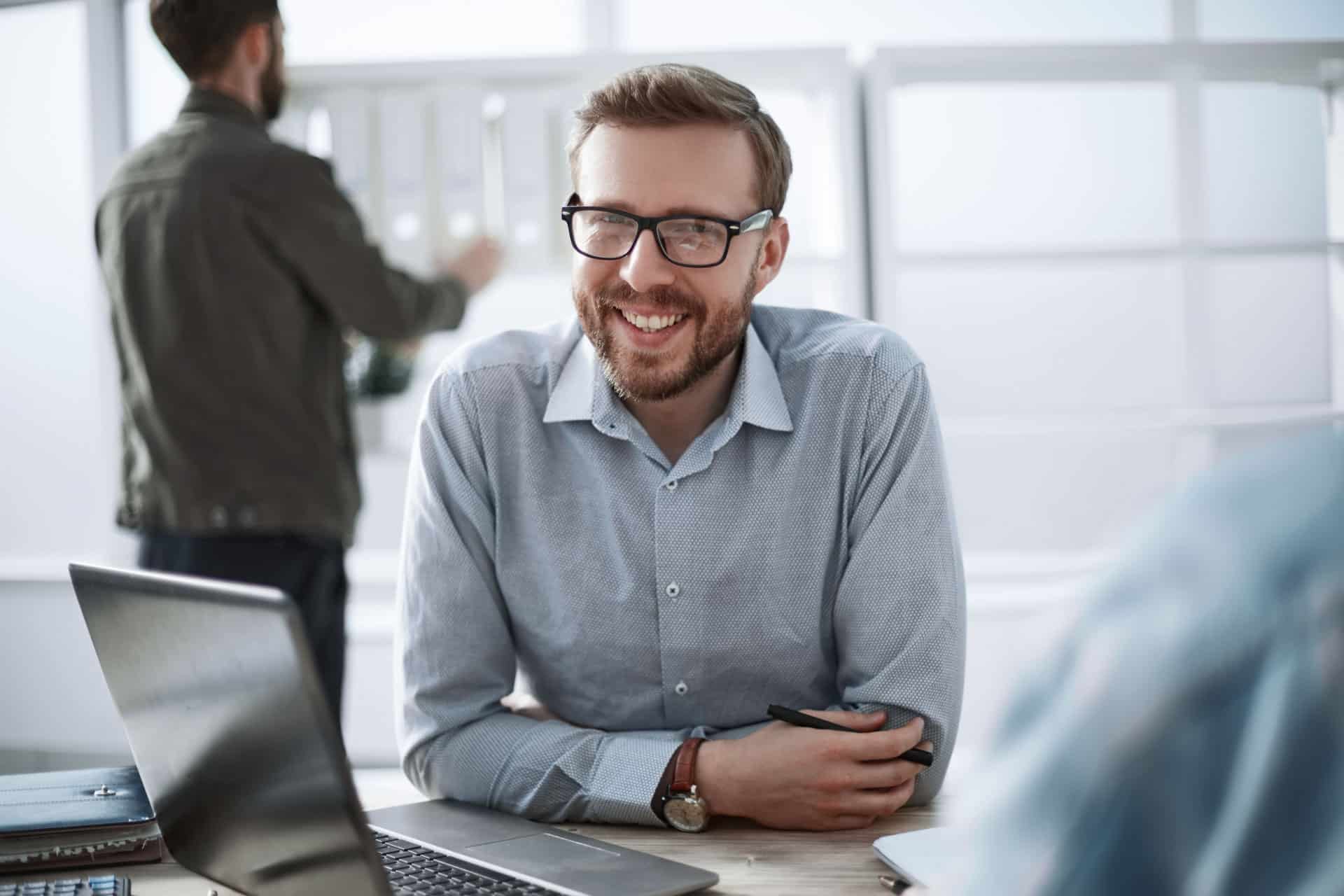 close up. smiling businessman sitting at his desk