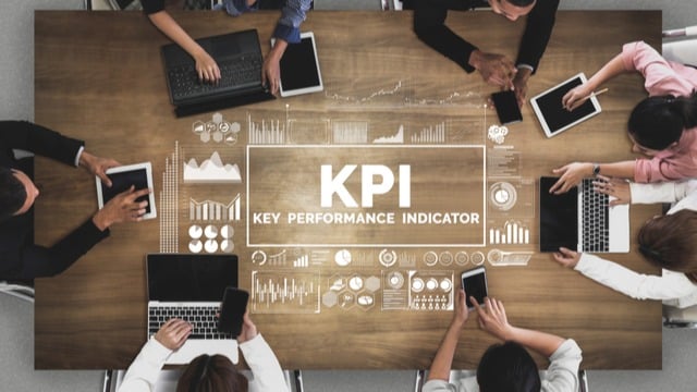 KPI written on a table with people around