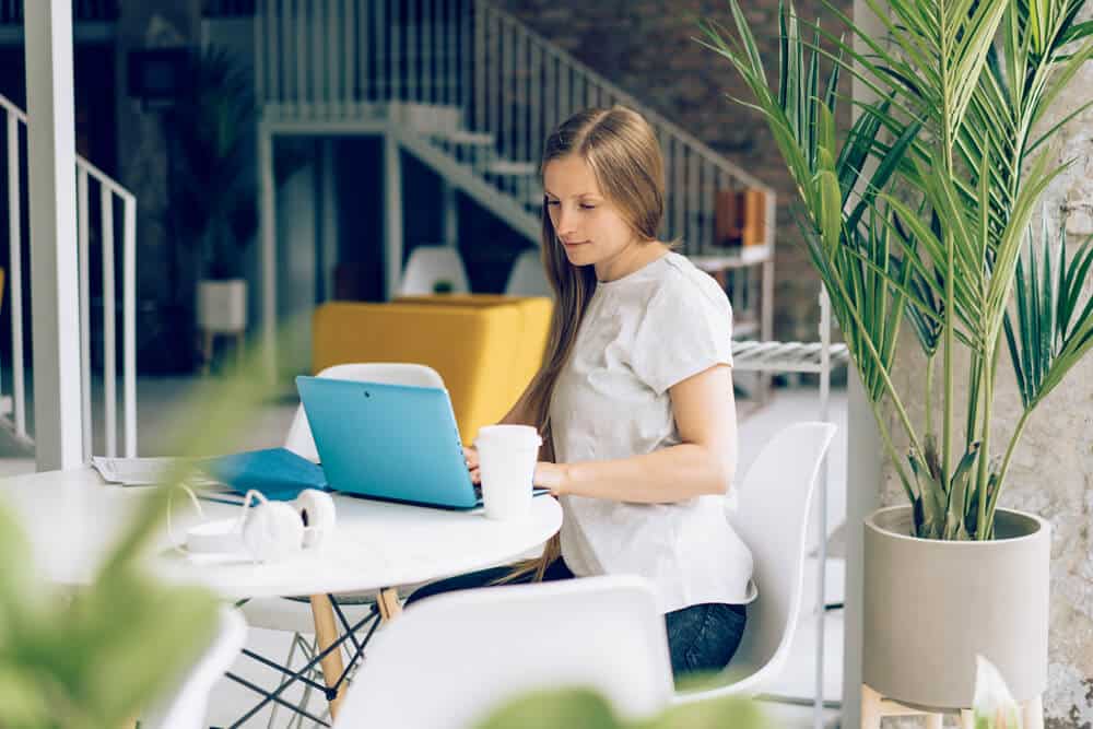 A lady working in an office with blue laptop