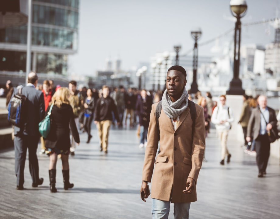 Black person waking in the busy street